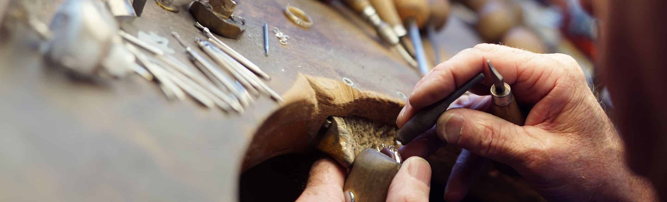 Goldsmith repairing a ring at a jewellers bench